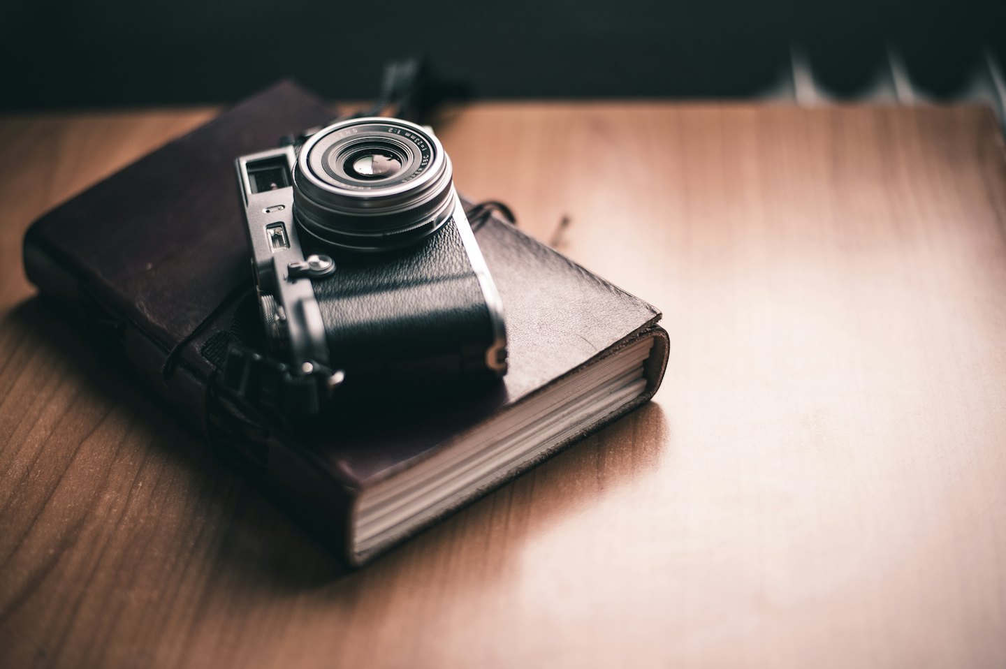 Vintage camera ligt op een leren notitieboek.